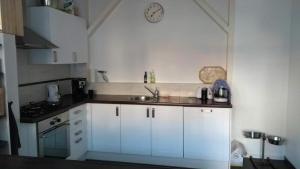 a kitchen with white cabinets and a sink at New City Garden view 5min TU Delft central room bentley utopia in Delft