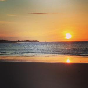 a sunset on the beach with the sun setting at MelBliss Gostoso in São Miguel do Gostoso