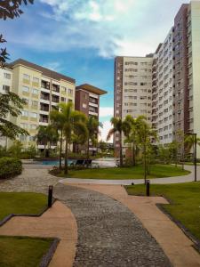a walkway in a park with palm trees and buildings at Spacious 2 Bedroom condo unit for rent in Iloilo City