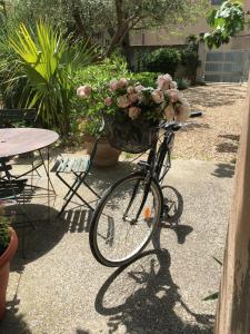 - un vélo avec un panier rempli de fleurs dans l'établissement Chez Marie, à Maillane