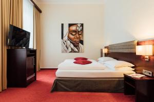 a hotel room with a bed and a television at Hotel de France Wiesbaden City in Wiesbaden