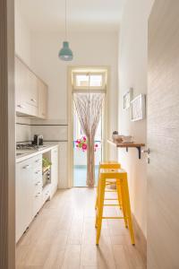 een gele kruk in een keuken met een raam bij Vento di Grecale - a pochi metri dal mare in Santa Flavia