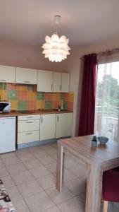 a kitchen with a wooden table and a chandelier at Apartment Ruby in Šibenik