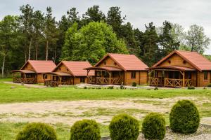 a row of log homes with red roofs at Gościniec Echo in Piecki