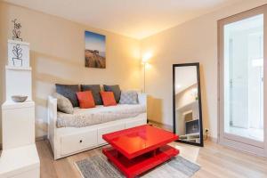 ein Wohnzimmer mit einem Sofa und einem roten Tisch in der Unterkunft studio next to bordeaux city center with a terrace in Bègles