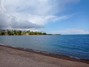een grote hoeveelheid water met een zandstrand bij Happy Hostel in Tamga in Tamga +13 foto's