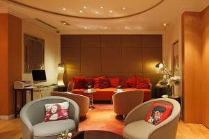 uma sala de estar com um sofá laranja e cadeiras em Westside Arc de Triomphe Hotel em Paris