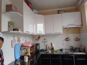 a kitchen with white cabinets and a sink at Happy Hostel in Tamga in Tamga