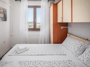 a small bedroom with a bed with a window at Apartments Špadići in Poreč