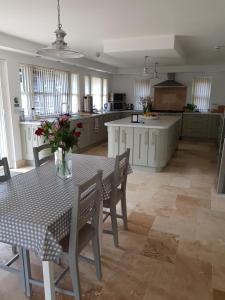 a kitchen with a table and chairs and a table and a kitchen at Tirah Guest House in Aldeburgh