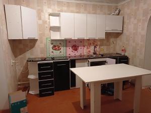 a kitchen with white cabinets and a white table at Happy Hostel in Tamga in Tamga