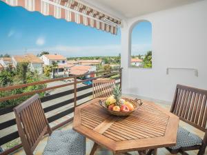a bowl of fruit on a wooden table on a balcony at Apartments Špadići in Poreč