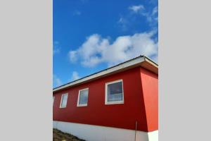 un edificio rojo con un cielo en el fondo en The red house near the sea, en Njarðvík