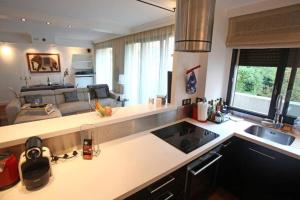 uma cozinha com um balcão e uma sala de estar em George Apartment in Neuilly em Neuilly-sur-Seine