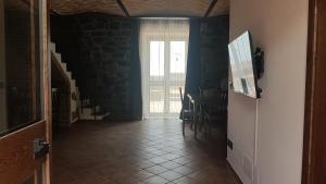 un pasillo con una habitación con una mesa y una ventana en La Gelsomina - Etna en Presa