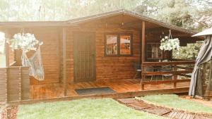 Cabaña de madera pequeña con porche y puerta en DOM LAS 2-natura, relaks, jacuzzi, akwen Jeziorsko en Kolonia Strachocice