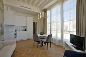 sala de estar con mesa, sillas y TV en Plaza Mina Suites - Adults Recommended by Luxury Suites Cadiz, en Cádiz