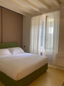 Fifty Eight Suite Milan Brera في ميلانو: غرفة نوم بسرير ونافذة كبيرة