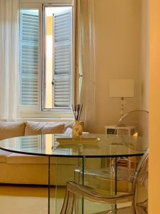 Fifty Eight Suite Milan Brera في ميلانو: غرفة معيشة مع طاولة زجاجية ونافذة