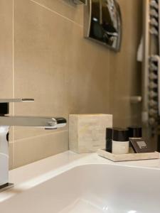 Fifty Eight Suite Milan Brera في ميلانو: بالوعة الحمام مع وجود صنبور على المنضدة