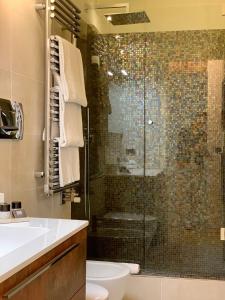 a bathroom with a shower and a toilet and a sink at Fifty Eight Suite Milan Brera in Milan +9 photos