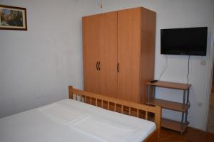 een slaapkamer met een bed en een kast met een televisie bij Holiday apartment in Drage with balcony, air conditioning, W-LAN 5013-1 in Drage