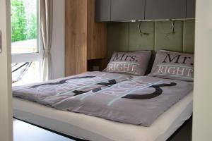 a bed with two pillows and a mr right comforter at Hiša Uran in Kobarid
