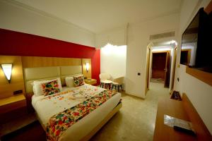 a hotel room with a large bed and a red wall at Oasis Hotel & Spa in Agadir