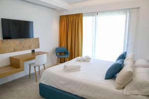 ein Schlafzimmer mit Bett, Schreibtisch und Fernseher in der Unterkunft Sunset Hotel in Cefalú + 49 Fotos