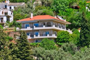 uma casa no lado de uma colina com árvores em House in Εndless green - Arethousa, Ikaria em Evdilos