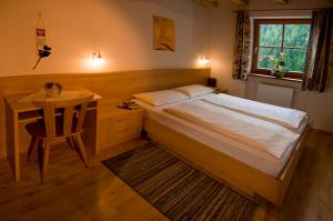 a bedroom with a bed and a table and a window at Residence Bad Bergfall in Valdaora