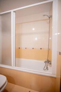 a shower in a bathroom with a tub at Noja Rooms in O Pedrouzo