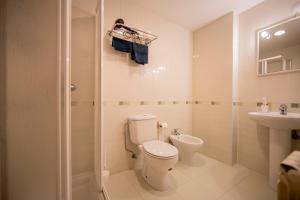 Un baño con inodoro, lavabo y ducha. en Noja Rooms, en O Pedrouzo