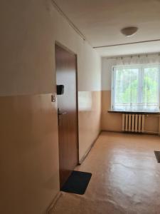 an empty room with a door and a window at Kawalerka blisko jeziora in Olecko