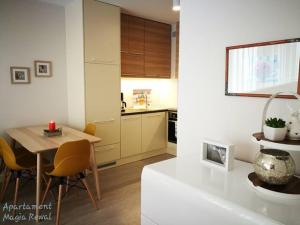 een keuken met een tafel en stoelen in een kamer bij Apartament Magia Rewal in Rewal