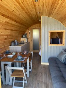 a dining room and kitchen in a log cabin at Allt Yelkie Pod Coig, Earlish in Earlish