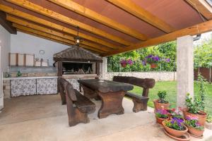a wooden table and bench under a wooden pergola at Apartments Špadići in Poreč