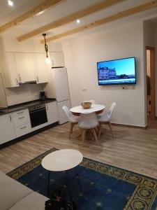 cocina con mesa y sillas y TV en la pared en casa CARREGAL, en Tomiño