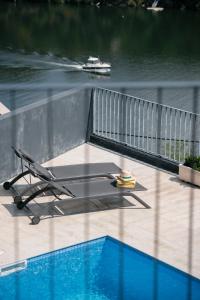 uma cadeira sentada num deque ao lado de uma piscina em Quinta do Pomar Maior Douro - Porto Carvoeiro em Porto Carvoeiro