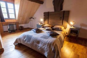a bedroom with a large bed with pillows on it at Longère Touraine Anjou in Hommes