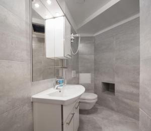 a white bathroom with a sink and a toilet at Riva Rooms in Split