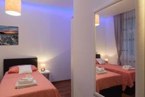 a bedroom with two beds and a mirror at Riva Rooms in Split