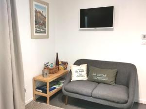 uma sala de estar com um sofá cinzento e uma mesa em Chambre d'hôtes LE SECADOU em La Ciotat