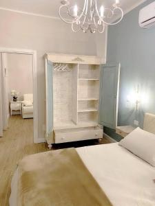 sypialnia z łóżkiem i żyrandolem w obiekcie Maison Marina_Pavia San Michele Centro Storico w mieście Pawia