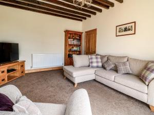 a living room with a couch and a tv at Hillcrest in Retford