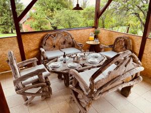 einen Holztisch und Stühle auf einer Veranda in der Unterkunft Holiday house in the heart of nature in Moravske-Toplice
