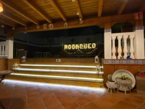 a restaurant with a row of benches and a sign at ROOMQUEO-Only Adults in Barbate
