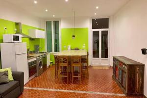 Loft provençal في ساليرنيس: مطبخ بجدران خضراء وطاولة وأريكة