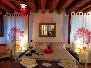 una camera con un letto e due finestre e uno specchio di Suite Ai Leoni a Venezia