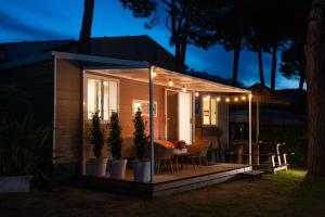 a tiny house with a porch at night at Luxury Caravan at Union Lido in Cavallino-Treporti